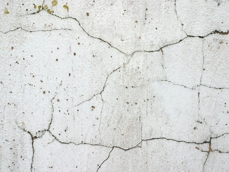 Cracked, damaged wall showing effects of no exterior textured wall coatings.