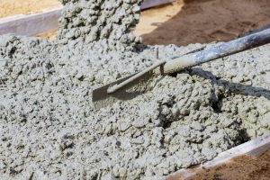 A close-up view of a thick render mix being spread with a trowel, illustrating the texture and consistency of the best render mix for winter.