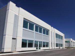 Commercial building showcasing the best cladding materials in modern architecture, featuring sleek white exteriors and large windows.