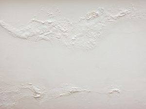 Bubbling Wall: Close-up of a wall with peeling paint and bubbling texture.