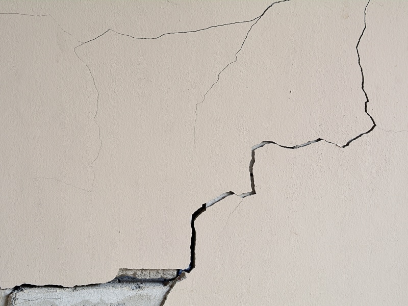 Cracked wall showing incorrect cement rendering. Damage is visible on the light-coloured surface.