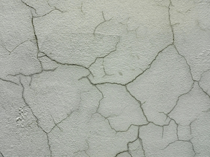 Widespread surface damage from cracked plaster walls during environmental exposure