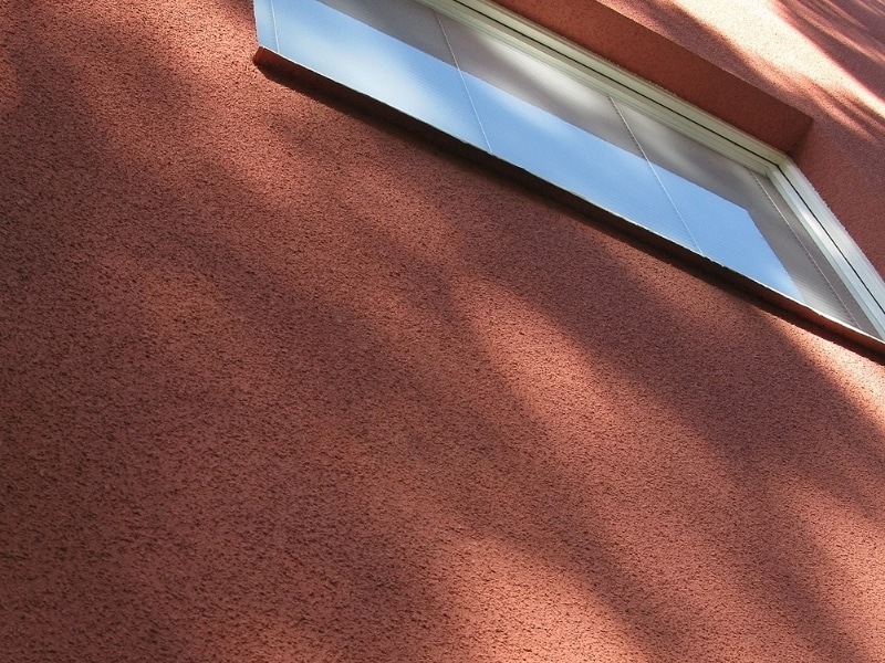 concrete texture coating on red exterior wall under daylight