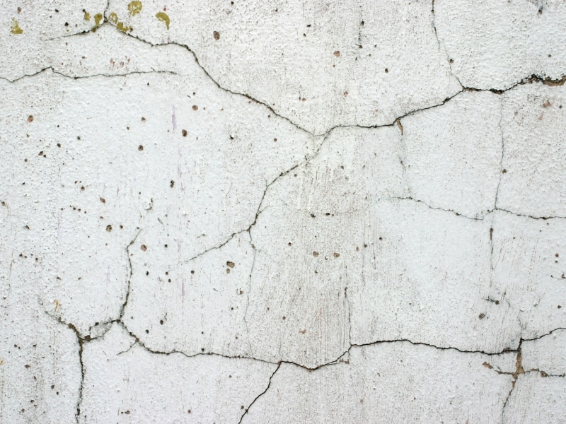 Cracked, damaged wall showing effects of no exterior textured wall coatings.