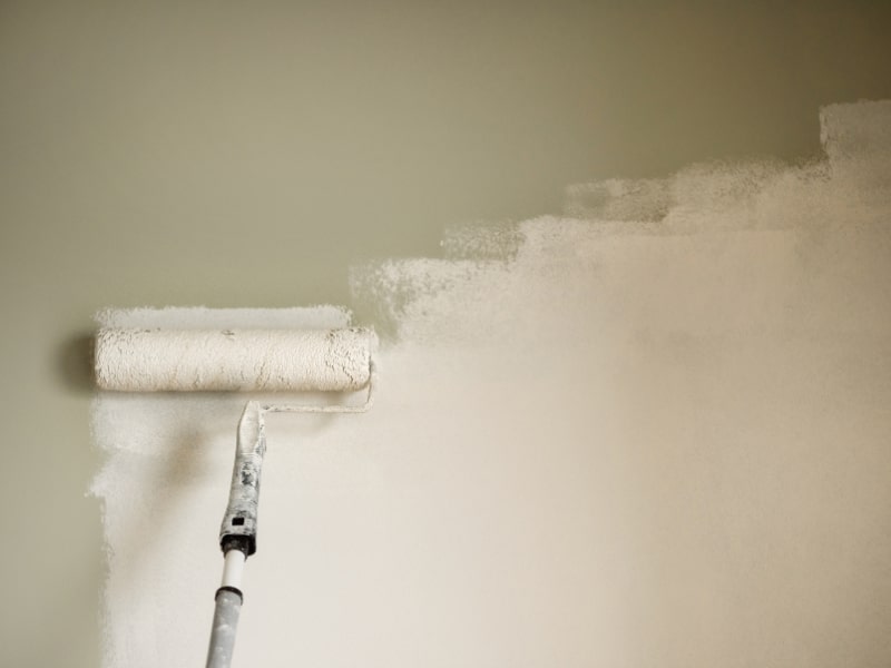 Applying exterior textured wall coatings with roller for even, lasting coverage.