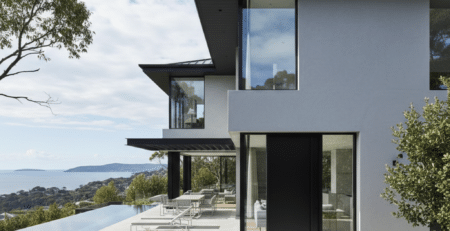 Modern rendered Sydney home exterior with light grey façade and black trim.