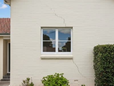 Diagonal crack in a rendered wall near a window on a Sydney home