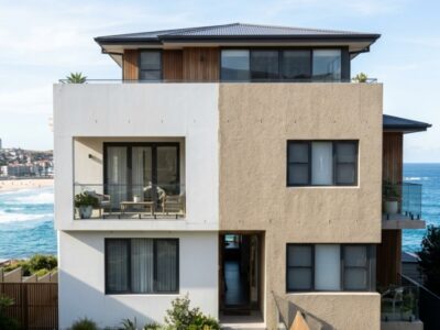 Sydney coastal home exterior in 2026, showing half with smooth painted finish and half with textured acrylic coating, bright afternoon light, subtle wear difference visible