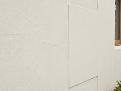 Rendered wall showing a localised repair beside older textured rende